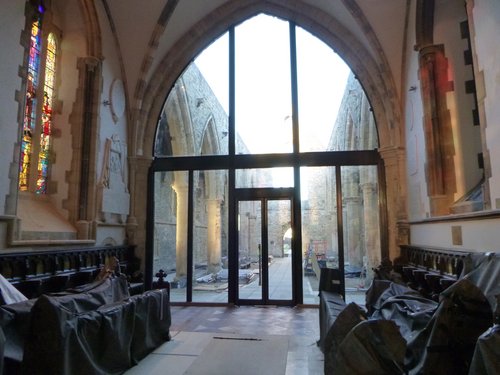 The multi-panel screen wall separates the roofless nave from the chancel.