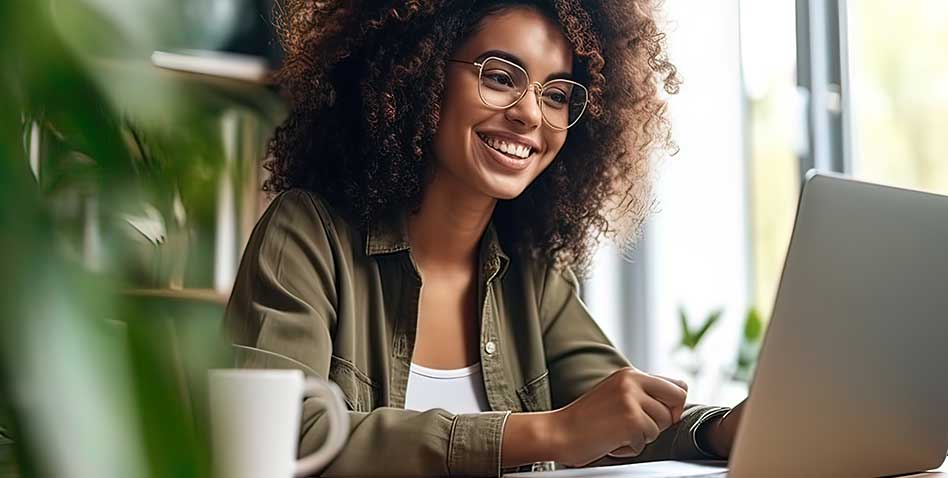 A beautiful girl with a smile on her face communicates with colleagues online, on a laptop